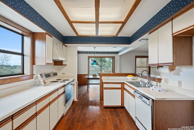 kitchen with white appliances, light countertops, wallpapered walls, and white cabinetry