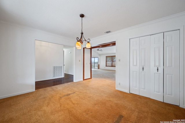 unfurnished dining area with carpet floors, visible vents, ornamental molding, and baseboards