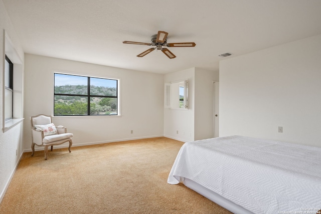 bedroom featuring light carpet, baseboards, visible vents, and ceiling fan