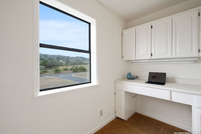 unfurnished office featuring carpet floors, built in study area, and baseboards