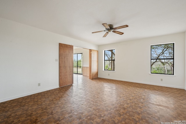 spare room featuring ceiling fan and baseboards