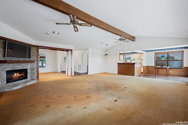 unfurnished living room with lofted ceiling with beams, light carpet, visible vents, and a healthy amount of sunlight