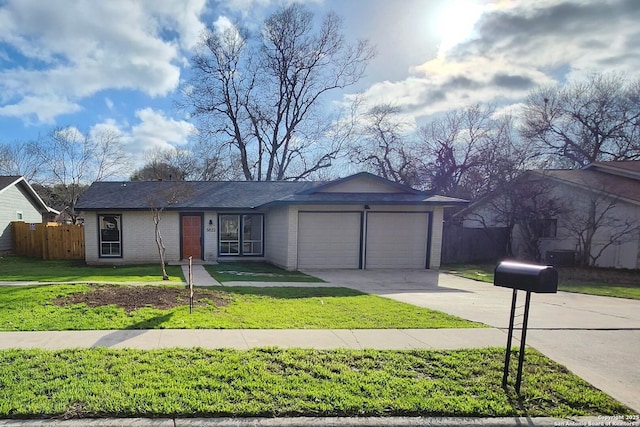 view of front of house with brick siding, fence, a garage, driveway, and a front lawn