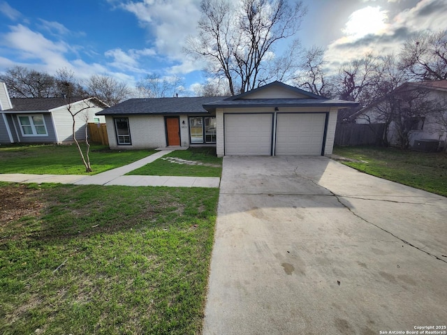 view of front of property with an attached garage, brick siding, fence, driveway, and a front lawn