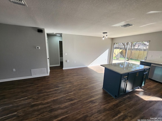 kitchen featuring visible vents, dark wood finished floors, a kitchen island, pendant lighting, and stainless steel dishwasher