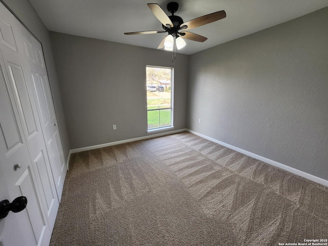 unfurnished bedroom with ceiling fan, a closet, carpet flooring, and baseboards