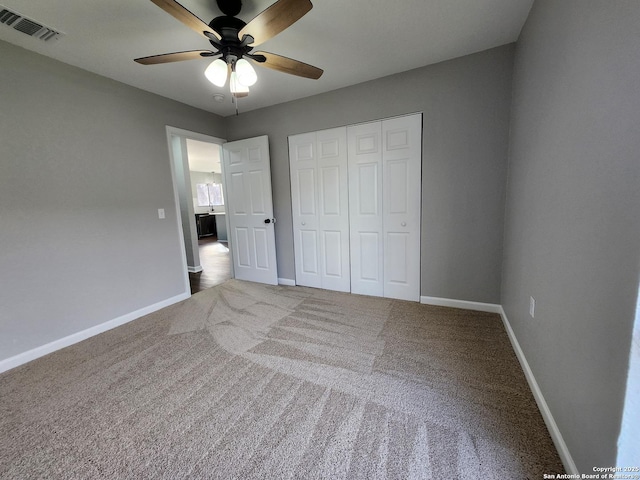 unfurnished bedroom featuring carpet, a closet, visible vents, and baseboards