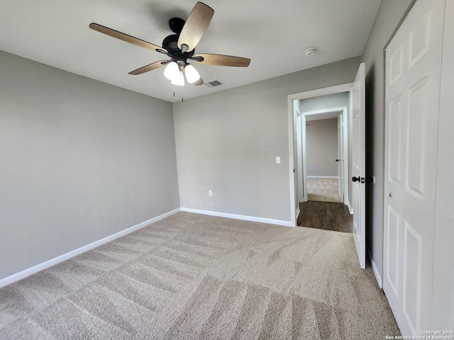 unfurnished bedroom with light carpet, baseboards, visible vents, and a ceiling fan