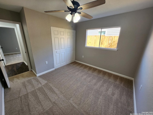 unfurnished bedroom with ceiling fan, baseboards, a closet, and carpet flooring