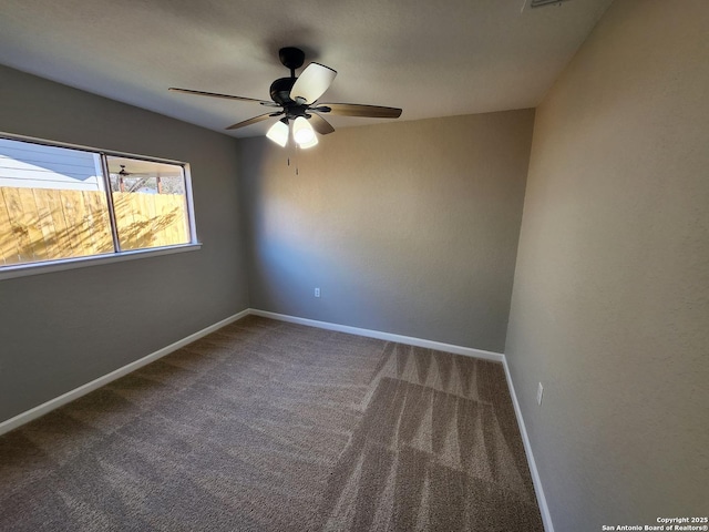 carpeted empty room with a ceiling fan and baseboards