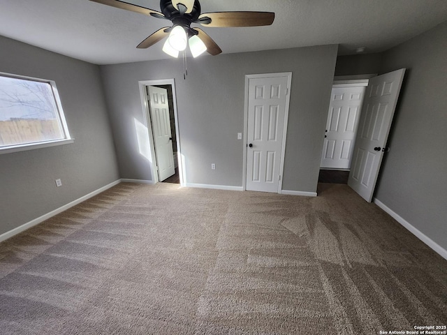 unfurnished bedroom with ceiling fan, baseboards, and carpet flooring