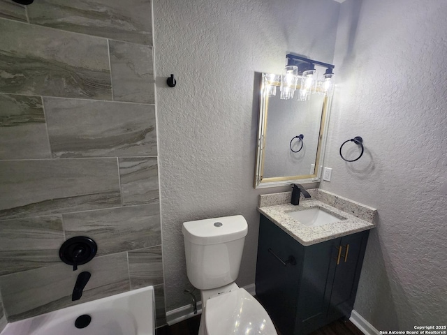 bathroom featuring a textured wall, vanity, and toilet