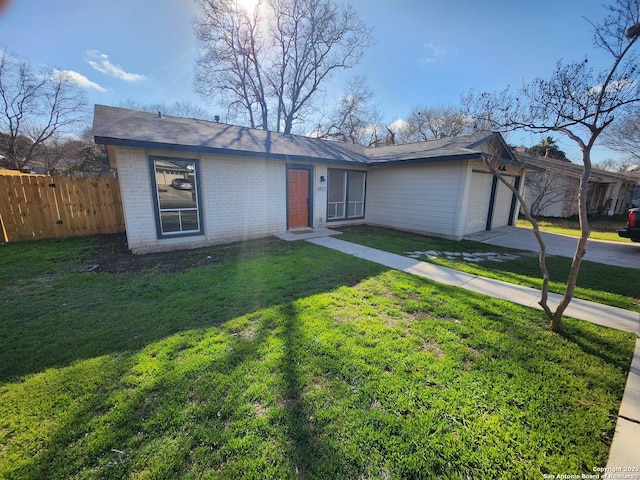 view of front facade with brick siding, concrete driveway, an attached garage, a front yard, and fence