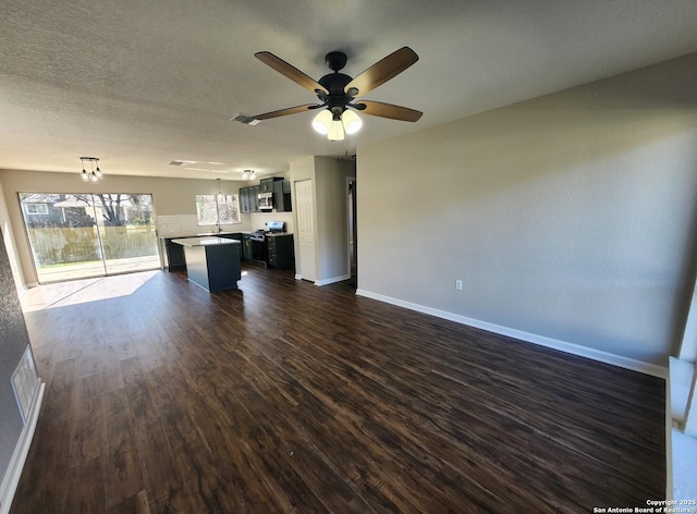 unfurnished living room featuring visible vents, dark wood-type flooring, ceiling fan, a textured ceiling, and baseboards