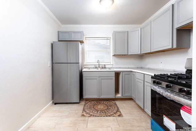 kitchen featuring sink, light tile patterned floors, appliances with stainless steel finishes, gray cabinetry, and ornamental molding