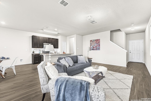 living room featuring dark hardwood / wood-style flooring and a textured ceiling