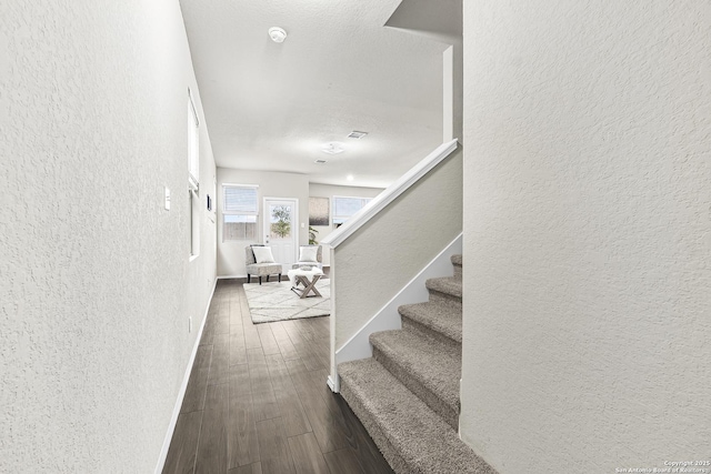 staircase with hardwood / wood-style flooring and a textured ceiling