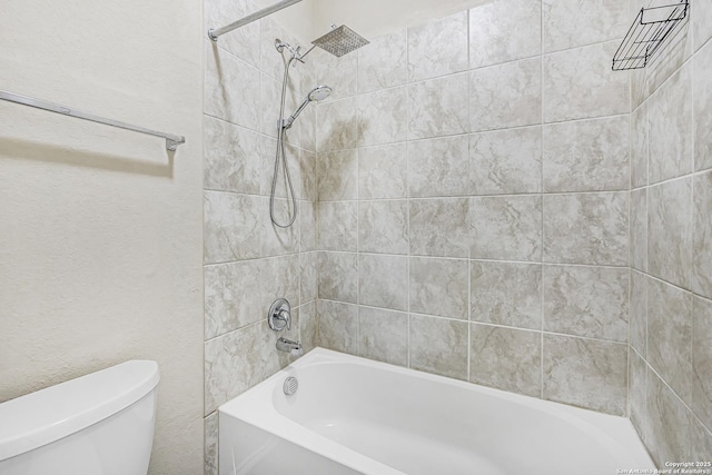 bathroom featuring tiled shower / bath and toilet
