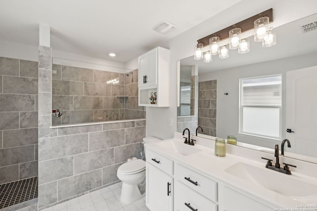 bathroom featuring toilet, walk in shower, a sink, and visible vents