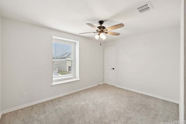 empty room with visible vents, ceiling fan, light carpet, and baseboards