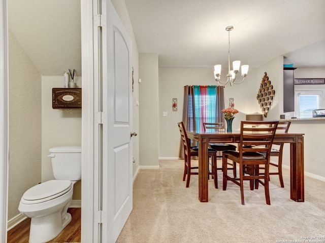 dining space featuring light colored carpet and a notable chandelier