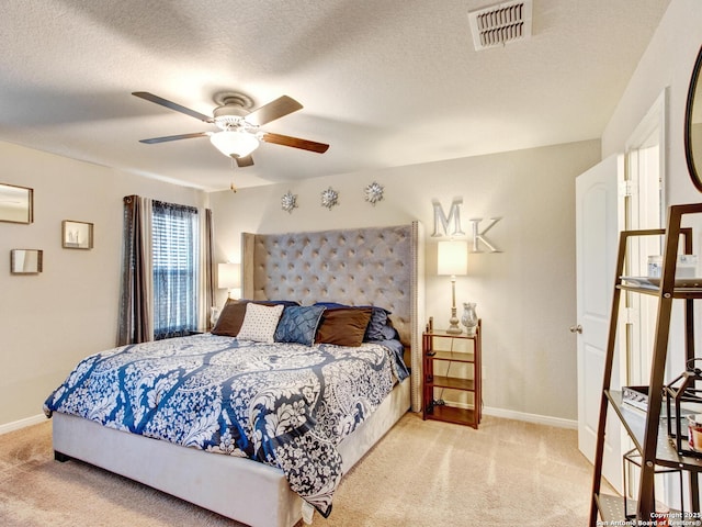 carpeted bedroom with ceiling fan and a textured ceiling