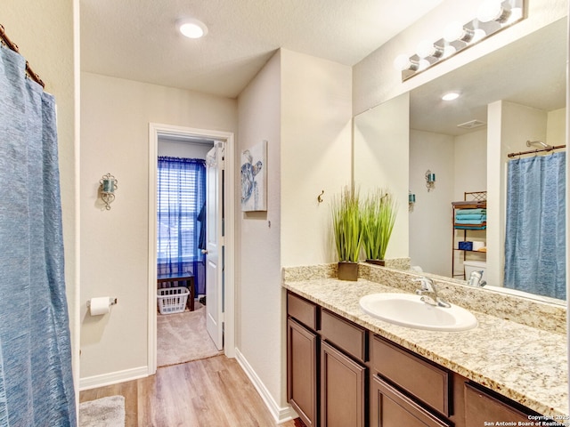 bathroom with vanity, hardwood / wood-style floors, and a textured ceiling