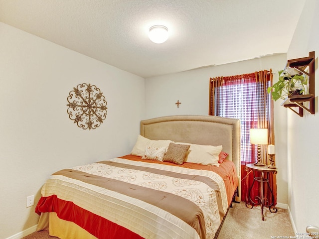 bedroom with carpet floors and a textured ceiling