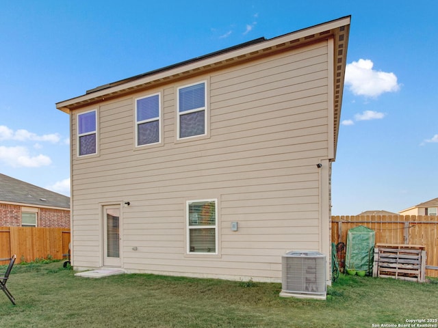 back of property featuring central AC and a yard