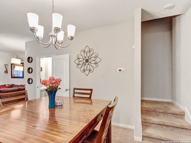 dining space with carpet flooring and a chandelier