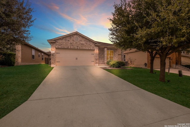 ranch-style home featuring a garage and a yard