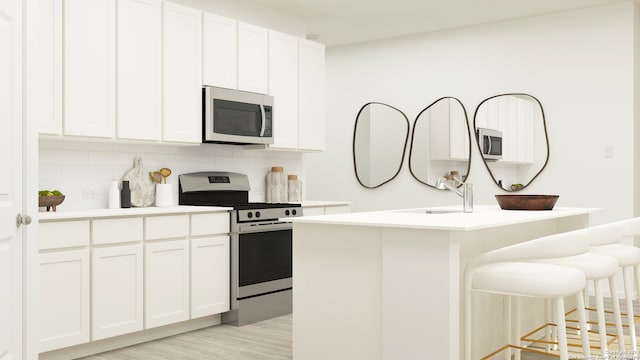 kitchen featuring tasteful backsplash, white cabinetry, sink, stainless steel appliances, and a center island with sink