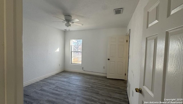 empty room featuring ceiling fan and dark hardwood / wood-style flooring