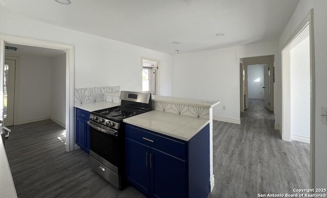 kitchen with dark hardwood / wood-style flooring, light stone countertops, stainless steel range, and blue cabinetry