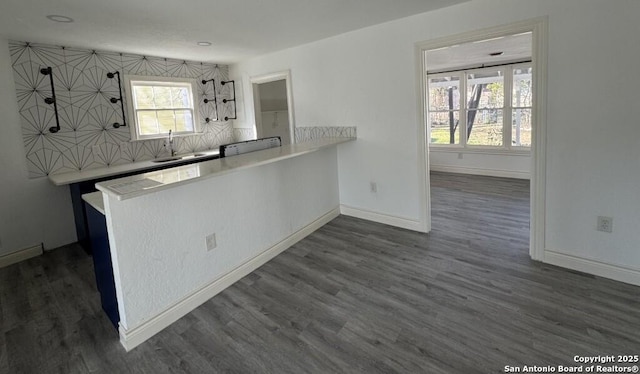 kitchen featuring sink, decorative backsplash, dark hardwood / wood-style floors, and kitchen peninsula