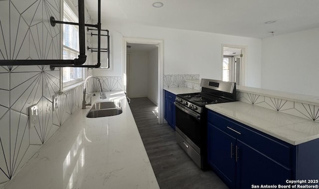 kitchen with sink, dark wood-type flooring, blue cabinetry, and gas stove