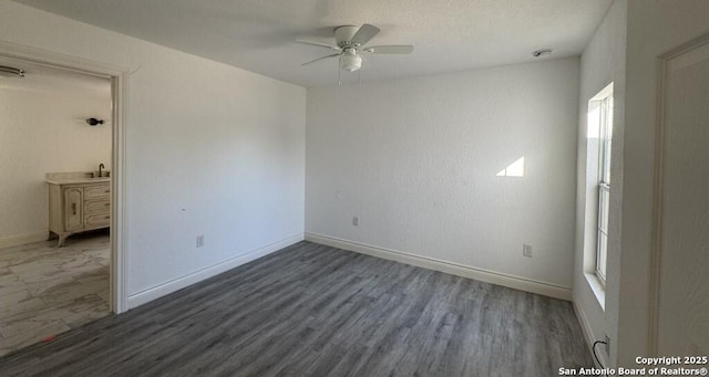 spare room featuring dark hardwood / wood-style floors and ceiling fan