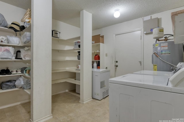 washroom featuring electric water heater, washer and dryer, and a textured ceiling