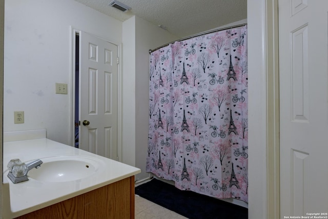 bathroom featuring vanity, a shower with shower curtain, and a textured ceiling