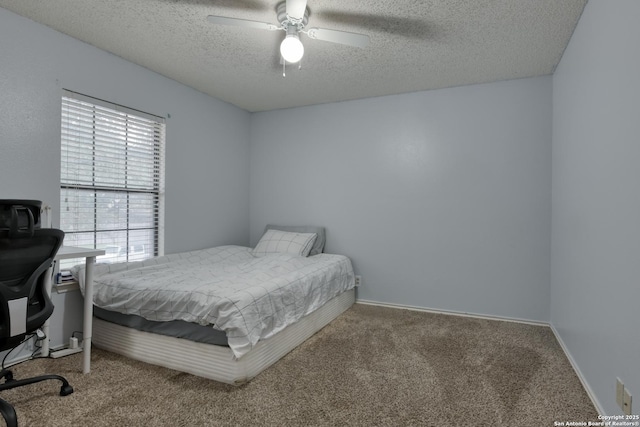 bedroom with ceiling fan, carpet flooring, and a textured ceiling