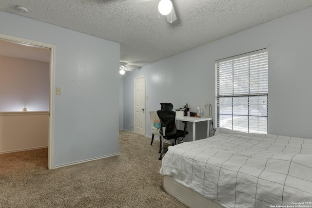 carpeted bedroom with ceiling fan and a textured ceiling