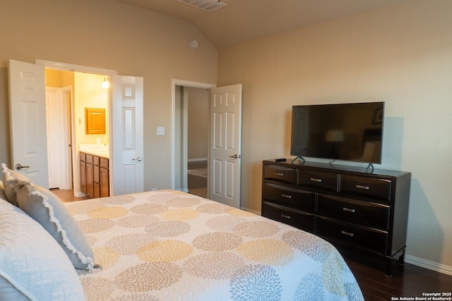 bedroom featuring vaulted ceiling, sink, dark hardwood / wood-style floors, and ensuite bathroom