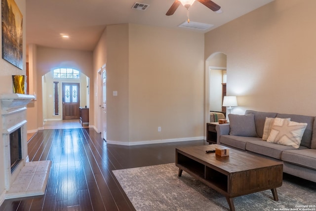 living room featuring dark wood-type flooring and ceiling fan