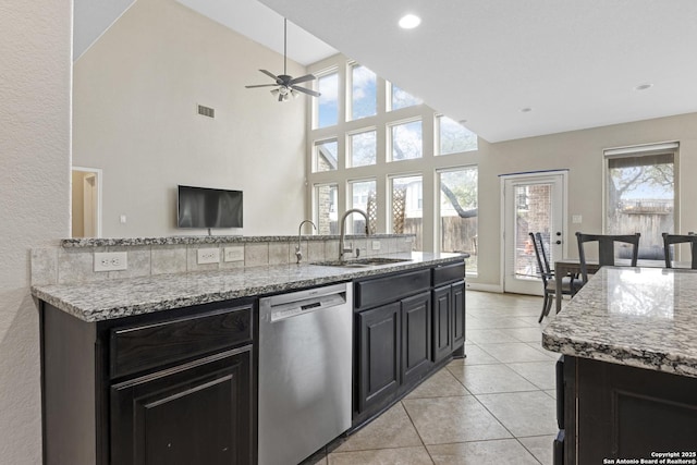 kitchen with sink, light stone counters, light tile patterned floors, stainless steel dishwasher, and ceiling fan