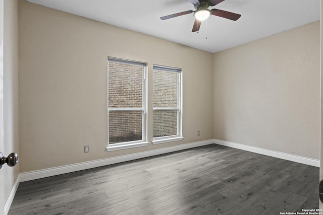 empty room with ceiling fan and dark hardwood / wood-style flooring