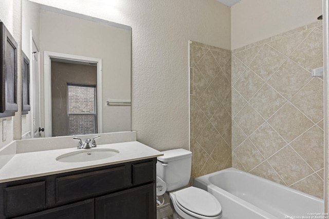 full bathroom featuring tiled shower / bath combo, vanity, and toilet