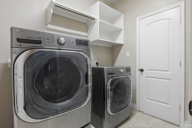 washroom featuring washing machine and dryer and light tile patterned floors