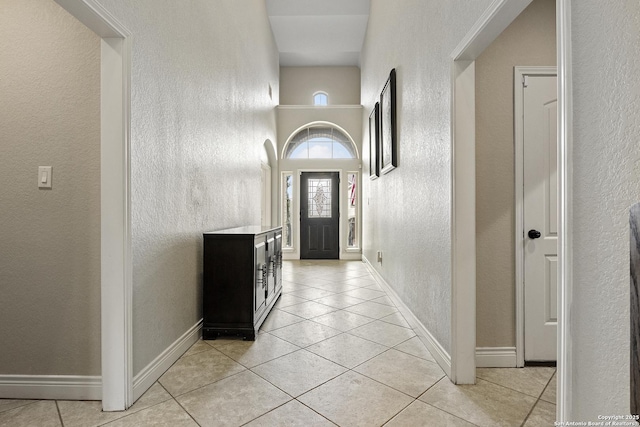 entryway with a high ceiling and light tile patterned floors