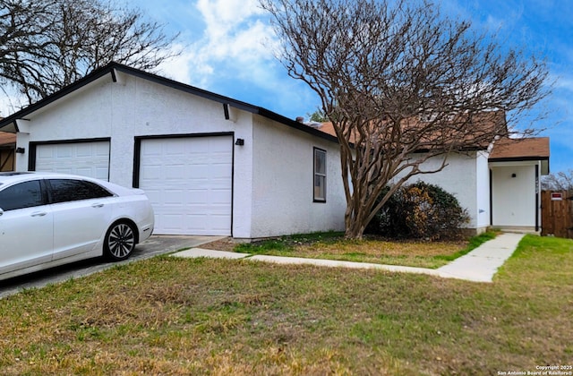 view of property exterior featuring a garage and a lawn