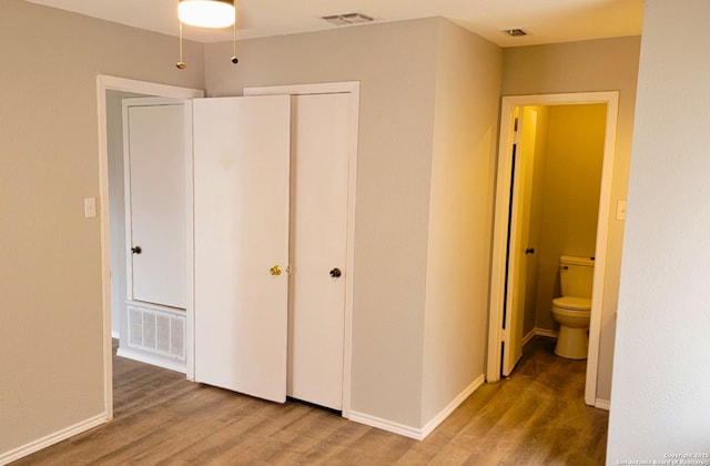 unfurnished bedroom featuring hardwood / wood-style floors and a closet